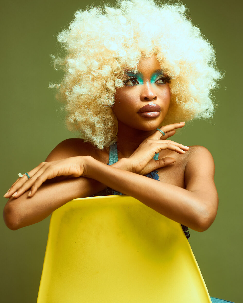 Editorial studio portrait, platinum afro on green