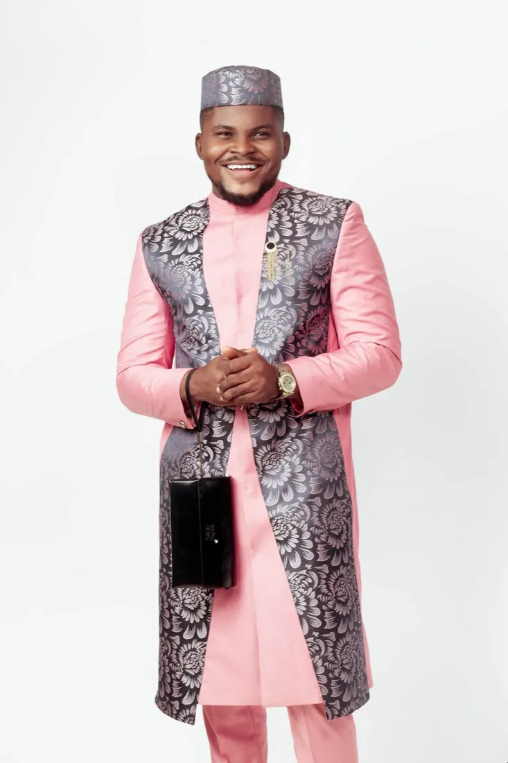 Portrait in a pink and silver brocade agbada with a matching cap