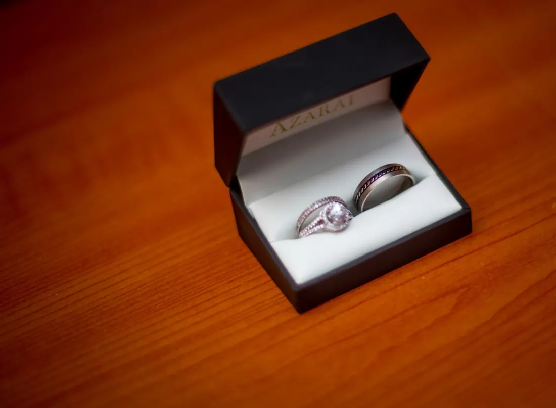 Wedding and engagement rings in an open box on a wooden table
